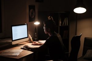 man focusing on computer writing a guest blog