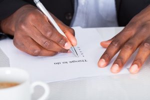 Close-up Of Businessman Hand Planning To Do List
